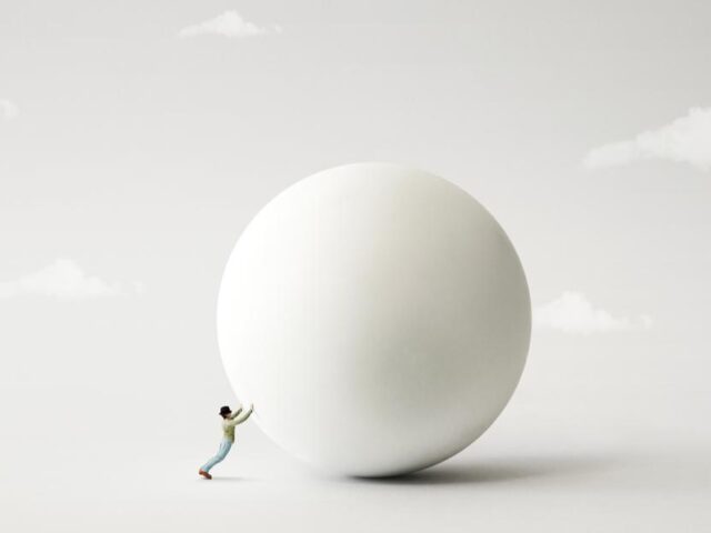 Man pushing large ball, to signify how to implement a successful lead generation strategy